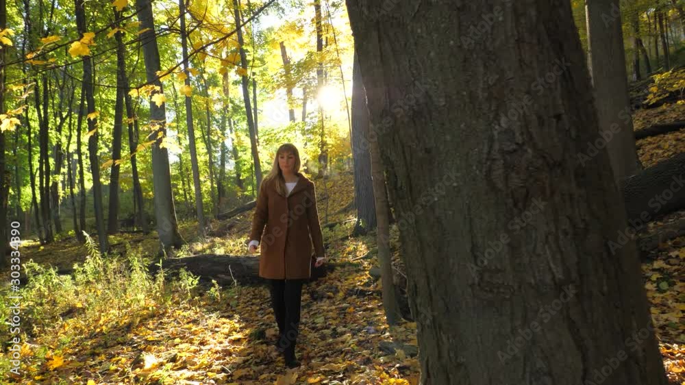 Female walking along sunny hiking trail with colorful leaves in autumn 11 Female walking along sunny hiking trail with colorful leaves in autumn 11