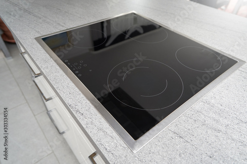 Built-in induction cooker with a black glass surface in the kitchen photo