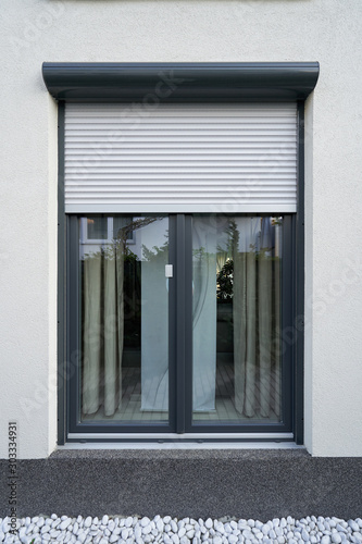Light roller shutter curtains mounted on a dark window