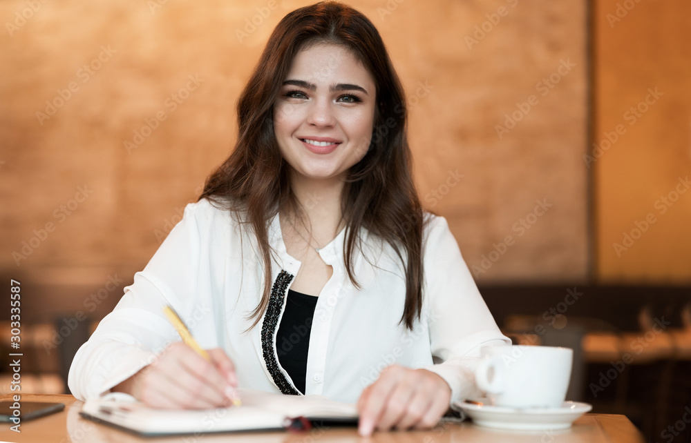 young beautiful woman taking notes to her planner working outside office drinking hot coffee in the cafe multitasking modern businesswoman young beautiful woman taking notes to her planner working outside office drinking hot coffee in the cafe multitasking modern businesswoman