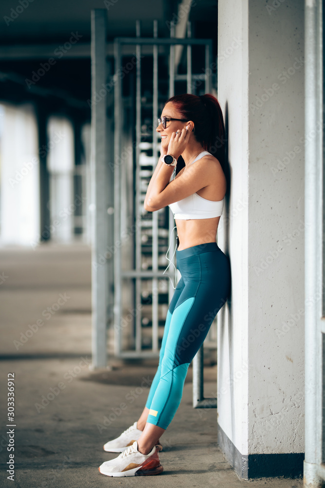 Portrait of attractive woman listening to music and training. Modern fitness concept