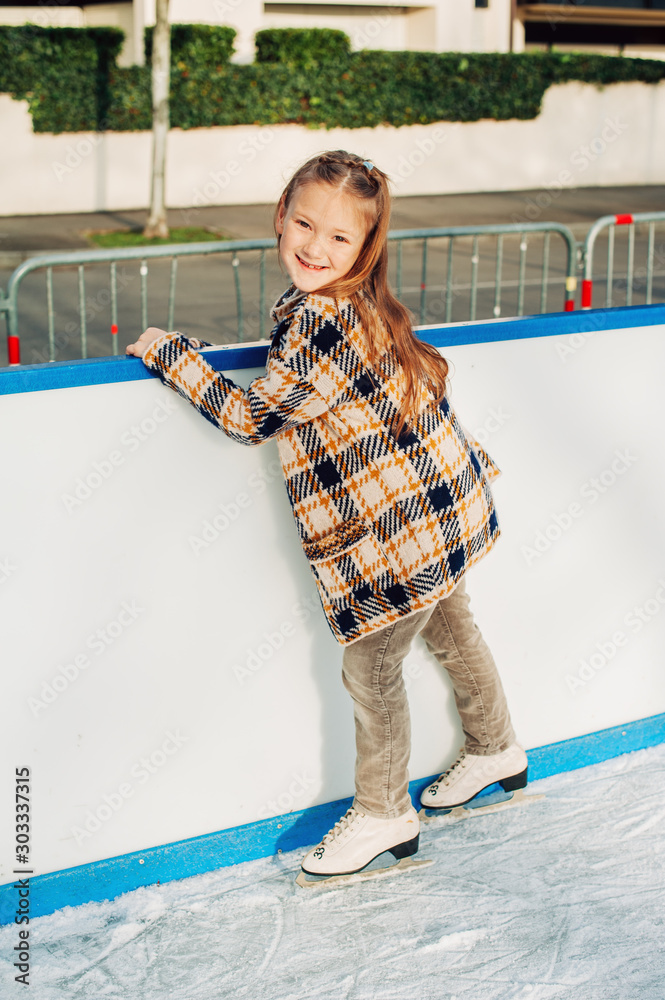 Φωτογραφία Outdoor portrait of cute little girl spending time on skating rink, winter fun f