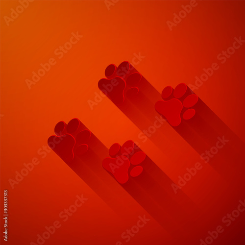 Paper cut Paw print icon isolated on red background. Dog or cat paw print. Animal track. Paper art style. Vector Illustration