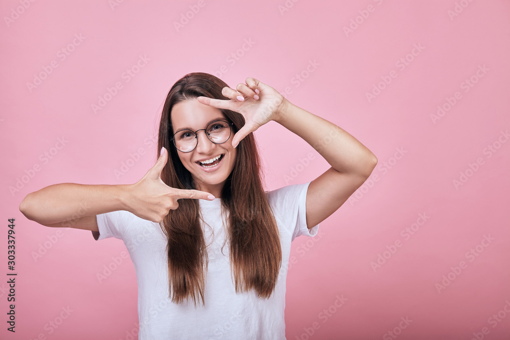 Cool happy smiling girl shows frame borders for photo with her hands Cool happy smiling girl shows frame borders for photo with her hands