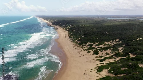 High Altitude Forward Flying Shot of Chidenguele Beach in Mozambique with Inhampavala Lake in Background photo