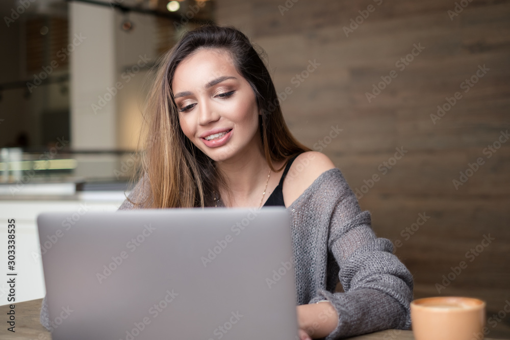 Happy woman working on laptop in the cafe Happy woman working on laptop in the cafe