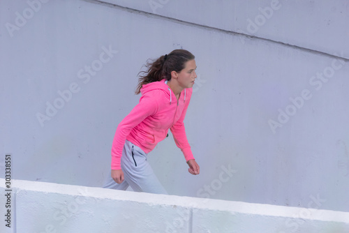 Running woman. Female fitness model training outside in the city.