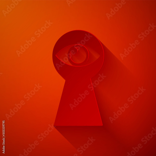 Paper cut Keyhole with eye icon isolated on red background. The eye looks into the keyhole. Keyhole eye hole. Paper art style. Vector Illustration