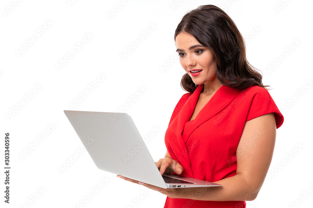 A young woman with red lips, bright makeup, works with a white laptop