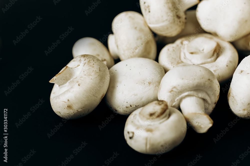 champignon mushrooms on a black background. space for text champignon mushrooms on a black background. space for text