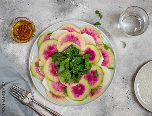 Photos detox salad of watermelon radish and arugula in a plate