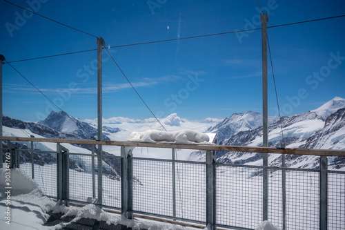Metal rails at view point of Jungfrau on beautiful view of snow mountain above cloud with clear blue sky background, copy space, Switzerland