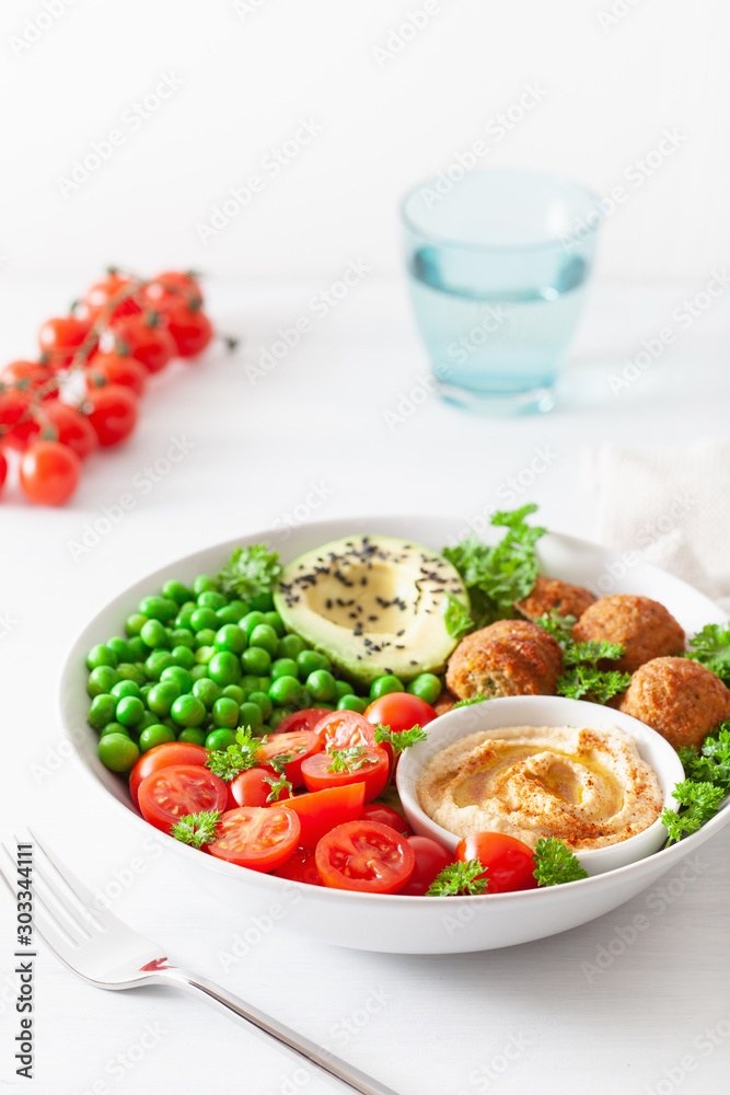 healthy vegan lunch bowl with falafel hummus tomato avocado peas