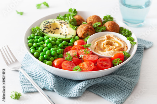 healthy vegan lunch bowl with falafel hummus tomato avocado peas