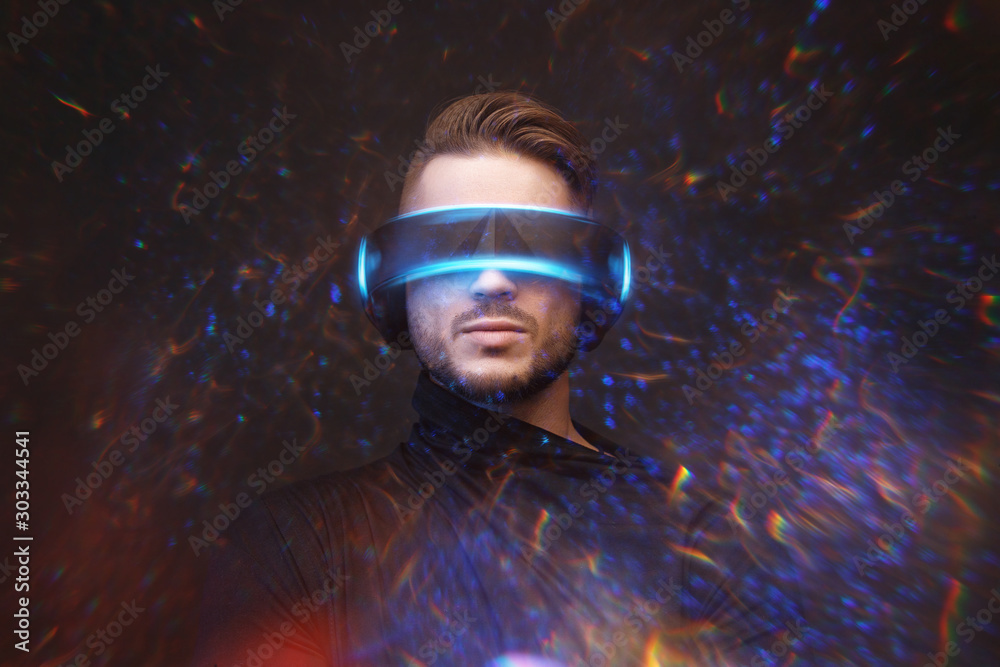 Young man on virtual reality background. Guy using VR helmet. Augmented reality, future technology, game concept. Blu neon light, fire flares. Young man on virtual reality background. Guy using VR helmet. Augmented reality, future technology, game concept. Blu neon light, fire flares.
