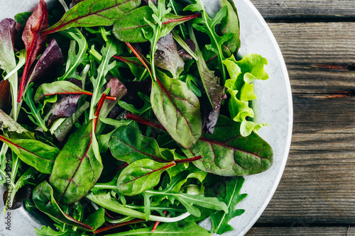 Papier peint Mix of fresh green salad leaves with arugula, lettuce, spinach and beets on wooden rustic background