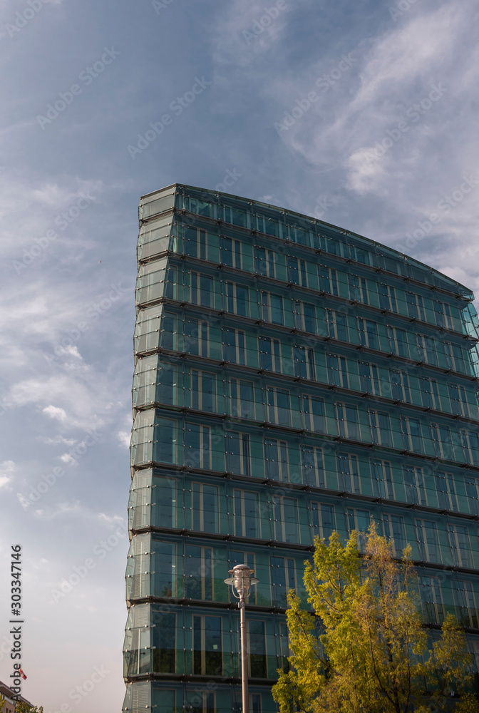 Perspective and lower viewing angle of a textured background of modern glass skyscrapers over a blue cloudy sky