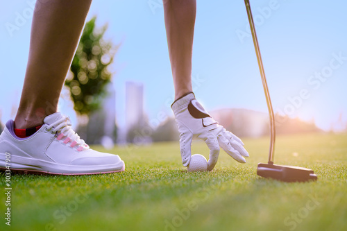 step of woman golfer going to takes a golf ball in the hole on the green after putted successfully winner in best score rate