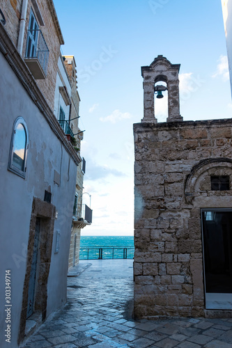 Evening winter on the streets of Polignano a Mare Old Town, Bari Province, Puglia region, southern Italy. Bell tower of Church of Santo Stefano. photo