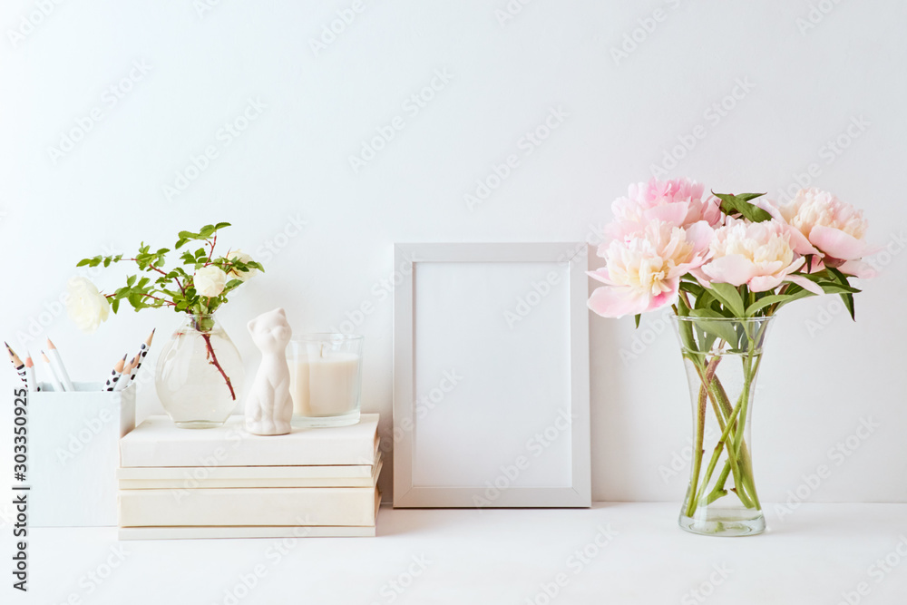 Home interior with decor elements. White frame, pink peonies in a vase, interior decoration Home interior with decor elements. White frame, pink peonies in a vase, interior decoration