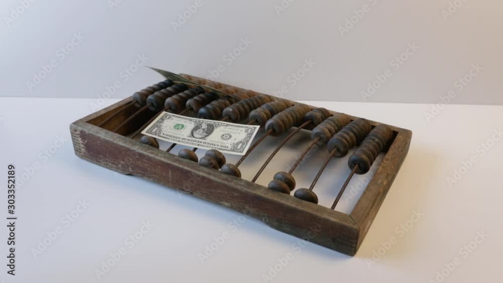 money dollars fly on top of wooden old abacus or wooden bills on a white background. Antique concept. money dollars fly on top of wooden old abacus or wooden bills on a white background. Antique concept.