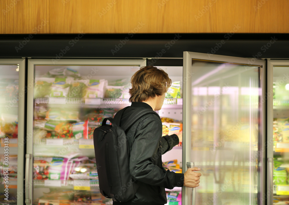 Man choosing frozen food from a supermarket freezer Man choosing frozen food from a supermarket freezer