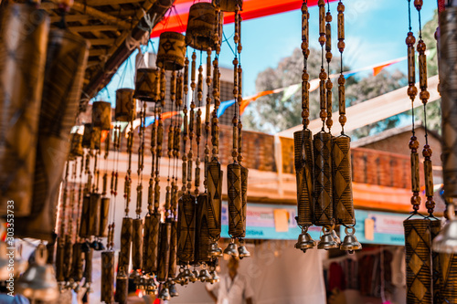 Wooden windchimes with musical bells for sale at Dilli Haat, an outdoor handicraft bazaar market in New Delhi India