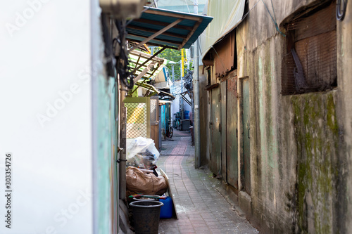 Narrow alley in the slums. Poor neighborhood. Marginal living standards. Garbage, old things and bicycles in the area where not rich people live