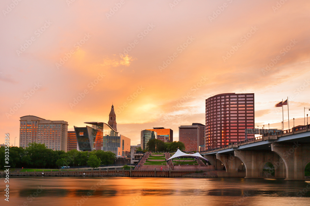 The skyline of Hartford, Connecticut at sunset. Photo shows Founders Bridge and Connecticut River. Hartford is the capital of Connecticut.  - obrazy, fototapety, plakaty 
