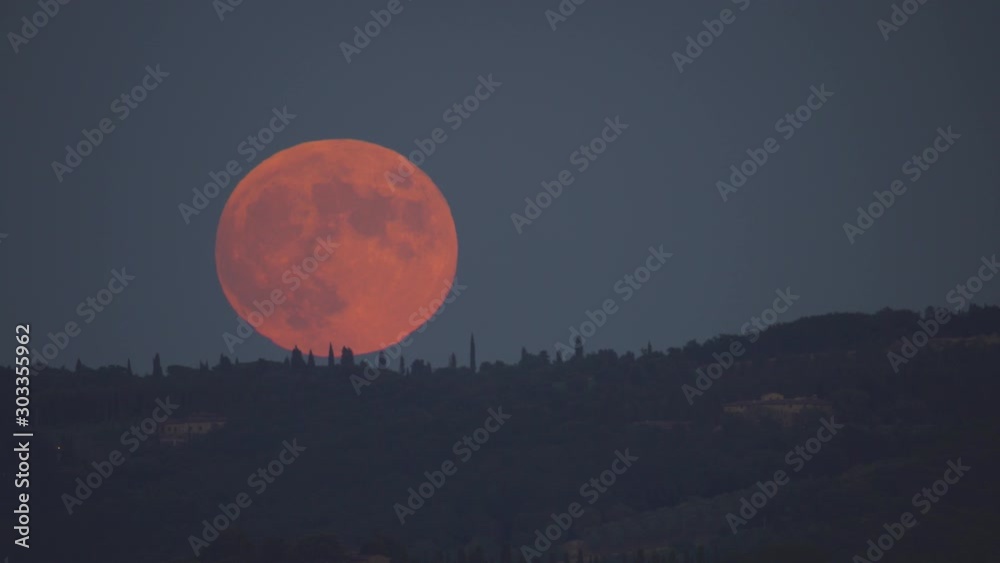 Red moon rising over hill during lunar eclipse Red moon rising over hill during lunar eclipse