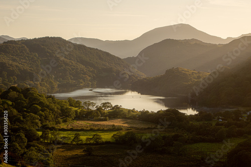 A view looking down the Nant Gwynant valley towards Llyn Gwynant with sun rays coming down from the mountains, this view towards Beddgelert is one of the most photographed in Snowdonia. photo