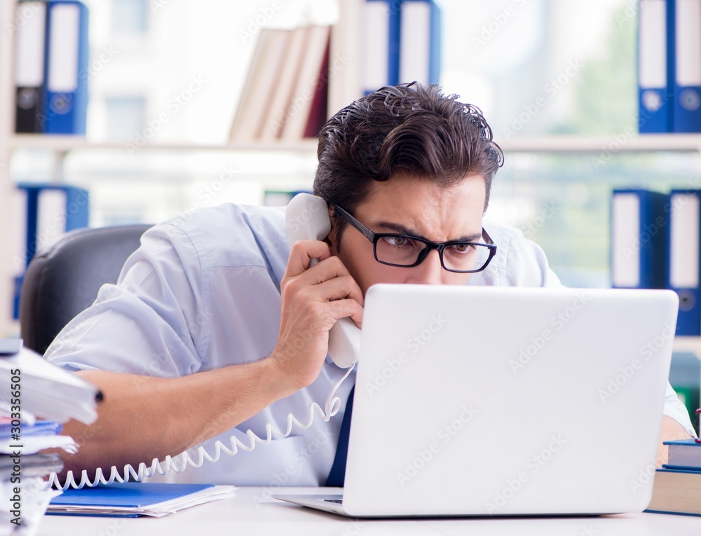 Businessman with excessive work paperwork working in office Businessman with excessive work paperwork working in office