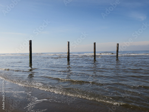 four wooden poles at the beach in the Northsea Zandvoort  The Netherlands