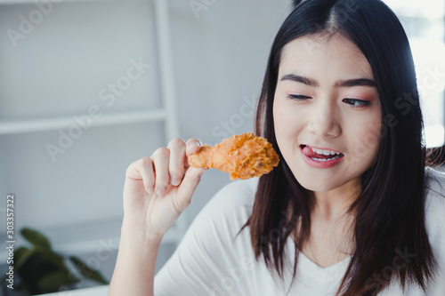 Girl holding fried chicken drumstick.