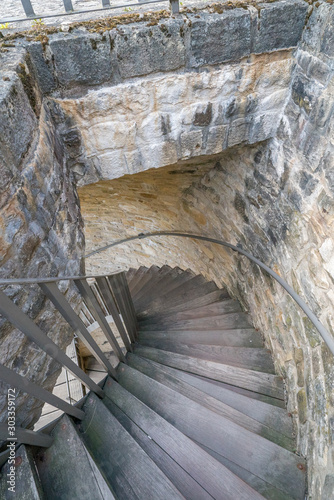 long and winding wooden staircase inside a massive stone city wall outer defense