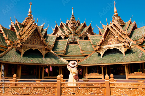 A woman tourist is sightseeing beautiful golden pavilion inside Ancient city (Muang Boran) in Thailand.