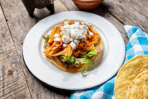 Mexican chicken tinga toasts with chipotle pepper and fresh cheese also called 