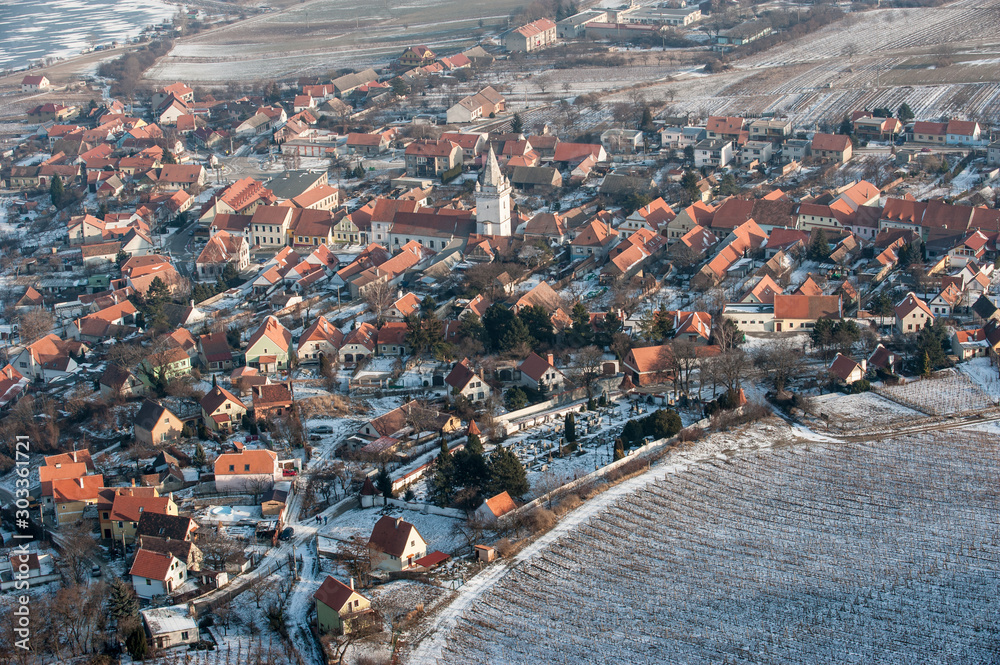 Aerial view of Dolni Vestonice village in winter. Birds eye view of frozen village and field. Snowcovered roofs.