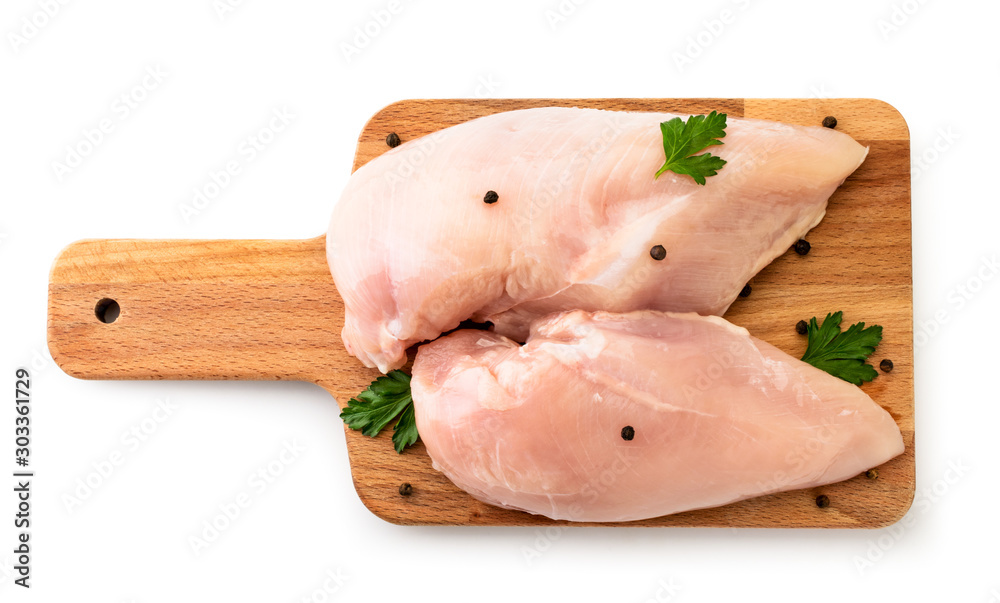 Raw chicken breast on cutting Board with pepper and parsley on white. The view of the top. Raw chicken breast on cutting Board with pepper and parsley on white. The view of the top.
