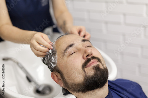 39-year-old man washes hair in a hairdressing salon