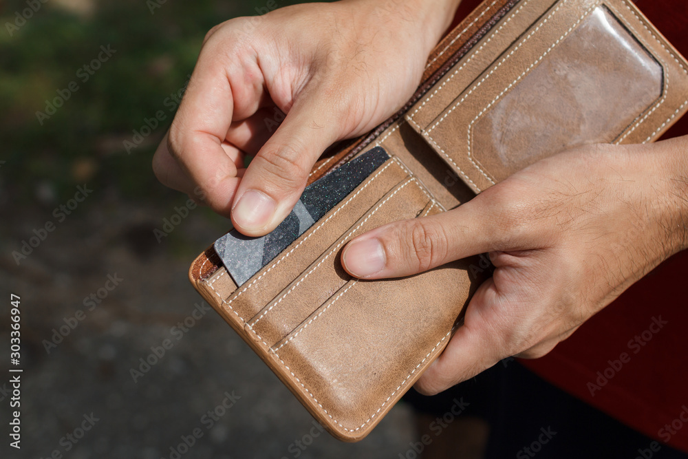 Obraz premium CLose up of a man hands as he is getting a credit card out of his wallet