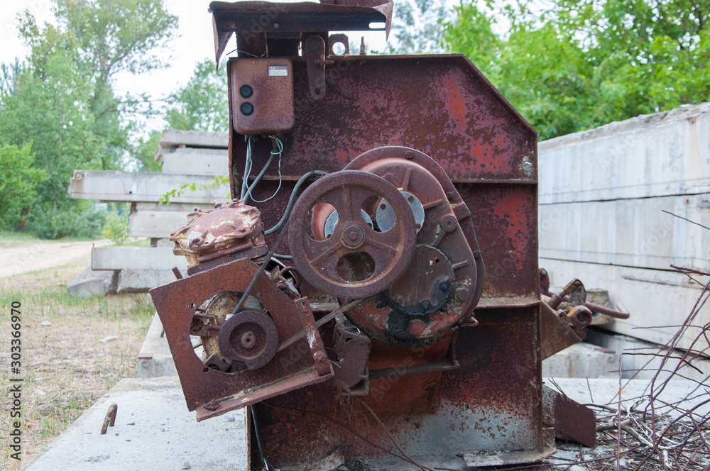 part of an old rusty concrete mixer. Pulley on the motor.
