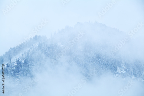 mountain in snow in dense fog