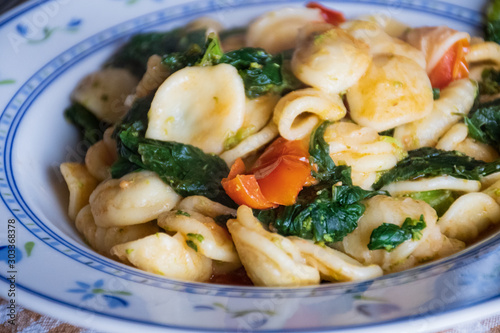 Dish of turnips leaves and fresh tomatoes with orecchiette in the traditional apulian recipe