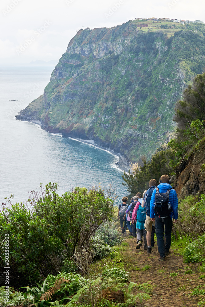 Reisegruppe läuft idyllisch an der Küste von Madeira den Berg hinunter