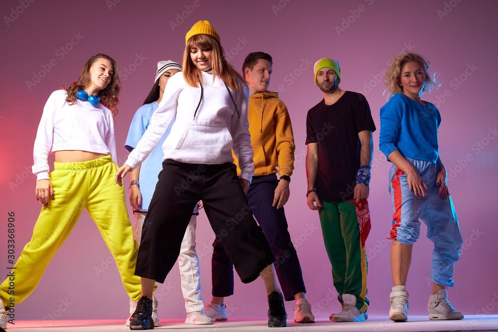 Φωτογραφία Young active people dressed in casual sport outfit, standing in full length on d
