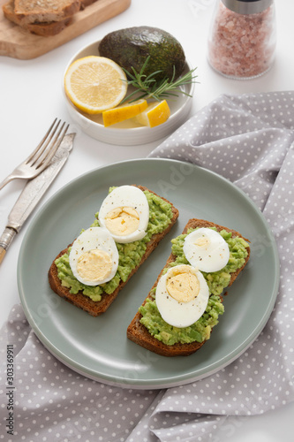 Avocado toast. Sandwich with egg, mashed on wholegrained bread. Healthy breakfast.