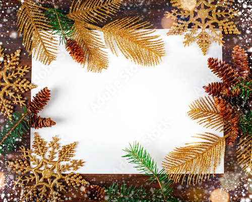 Christmas background with fir tree branch and golden ornaments. Free space for text or design.