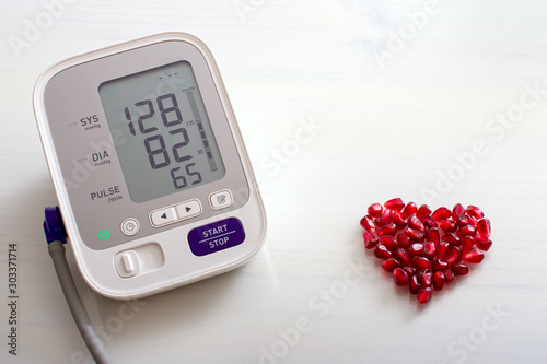 Blood pressure monitor with result of measurement, fresh fruits with vegetables and tape measure, healthy lifestyle, slimming and prevention of hypertension concept photo