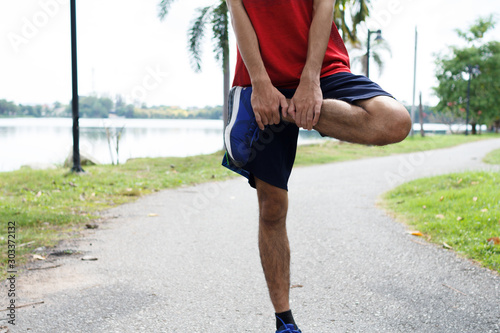 Young man runner warm up before run - workout concept